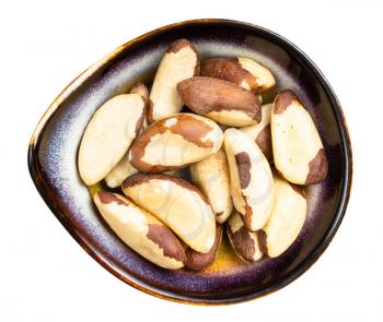 top view of raw brazil nuts in ceramic bowl isolated on white background