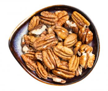 top view of shelled pecan nuts in ceramic bowl isolated on white background