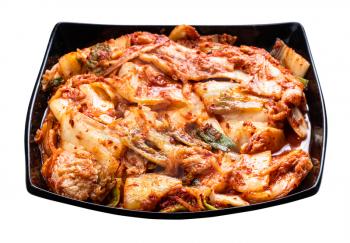 korean appetizer kimchi from napa cabbage in black bowl isolated on white background