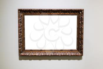 old carved wide dark brown picture frame with cutout canvas on gray wall