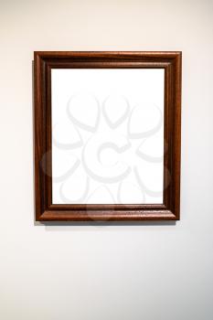 old vertical wide dark brown wooden picture frame with cutout canvas on gray wall