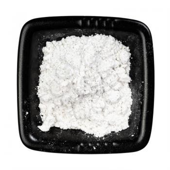 top view of vanilla sugar (sugar powder with ground natural vanilla) in black bowl isolated on white background