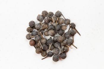 top view of pile of tailed pepper (cubeb) close up on gray ceramic plate