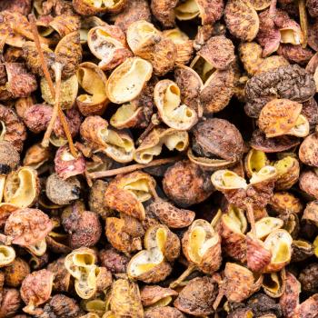 square food background - dried pink sichuan pepper close up