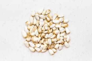 top view of pile of safflower seeds close up on gray ceramic plate