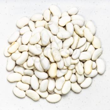 top view of pile of white beans close up on gray ceramic plate