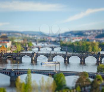 Travel Prague concept background - elevated view of bridges over Vltava river from Letna Park with tilt shift toy effect shallow depth of field. Prague, Czech Republic