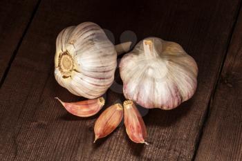 Garlic and cloves on old wooden background