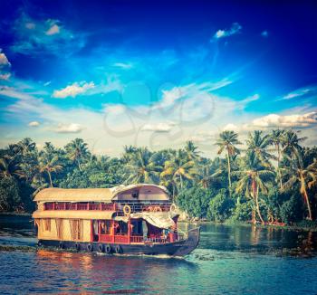 Vintage retro hipster style travel image of Kerala travel tourism background - houseboat on Kerala backwaters. Kerala, India