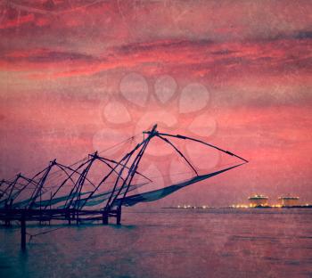 Vintage retro hipster style travel image of Kochi chinese fishnets on sunset. Fort Kochin, Kochi, Kerala, India