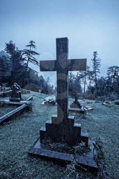 Spooky Halloween graveyard in fog in moonlight