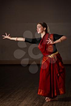 Young woman in sary dancing classical traditional indian dance Bharat Natyam