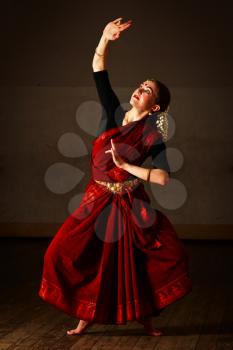 Young woman in sary dancing classical traditional indian dance Bharat Natyam