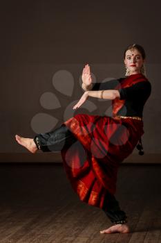 Young woman in sary dancing classical traditional indian dance Bharat Natyam