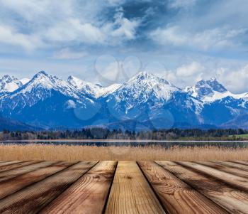 Wooden planks floor with Bavarian Alps countryside lake landscape in background. Bavaria, Germany