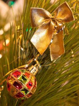 Christmas bow and ball on a green pine branch.