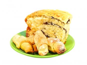 Piece of poppy cake and cookies on green plate isolated on white background.