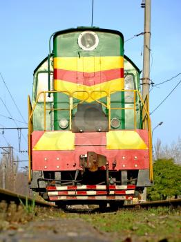 The multicolored locomotive on the rails.