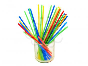 Multicolored cocktail straws in a transparent glass on a white background.