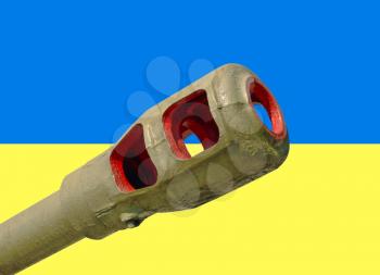 Artillery cannon taken closeup against of Ukrainian flag.War in Ukraine.