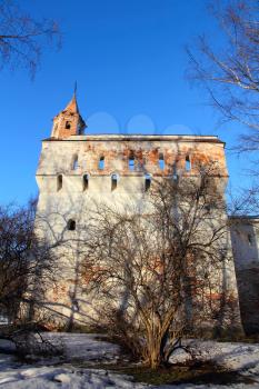 Old castle tower in winter on blue sky background.