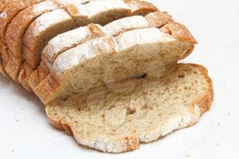 Fresh sliced bread taken closeup on white fabric background.