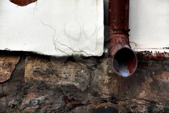 Old grunge rain gutters on worn home wall taken closeup.Toned image.