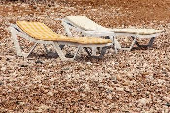 Dangerous vacation.Two vacant chaise lounge on the beach.