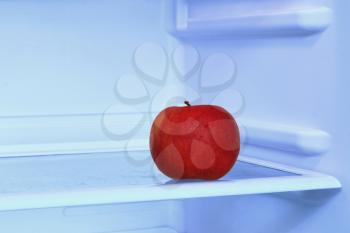 Healthy lifestyle.Red apple in domestic refrigerator taken closeup. Toned image.