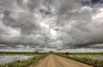 Storm Clouds Saskatchewan gravel grid road and pond