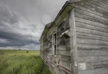 Abandoned Farm with storm clouds in the Canadian Prairie