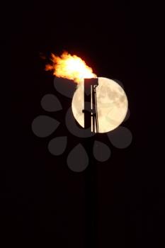 Full moon behind natural gas flame