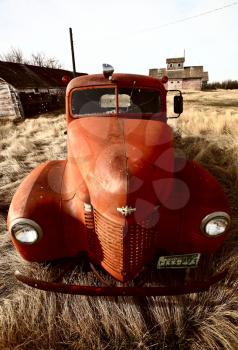 Old farm truck abandoned near unused wooden buildings