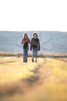 Two girls walking along causeway in scenic Saskatchewan