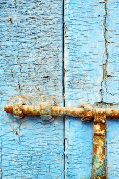 metal nail dirty     stripped paint in the brown   red wood door and rusty  knocker