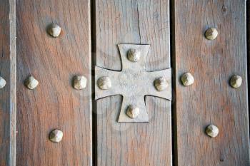  lombardy   arsago seprio abstract   rusty brass brown knocker in a  door curch  closed wood italy   cross