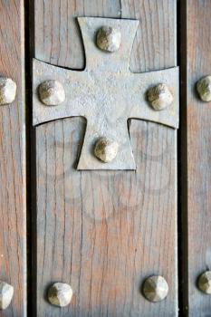 lombardy   arsago seprio abstract   rusty brass brown knocker in a  door curch  closed wood italy   cross

