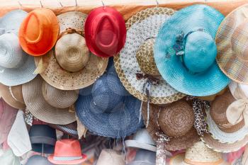 in a old market lots of colorated hats  like background clothes