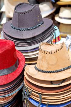 in a old market lots of colorated hats  like background clothes