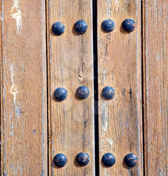stripped paint in the blue  wood door and rusty   nail