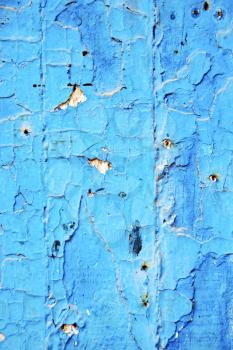 stripped paint in the blue wood door and rusty  nail