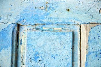 stripped paint in the blue wood door and rusty  nail