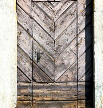 arsago seprio abstract   rusty brass brown knocker in a  door curch  closed wood italy  lombardy 