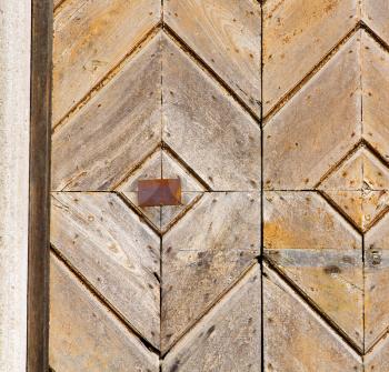  cross lombardy   arsago seprio abstract   rusty brass brown knocker in a  door curch  closed wood italy