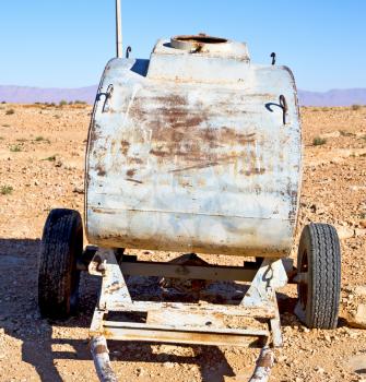 water tank in morocco africa land gray  metal weel and arid