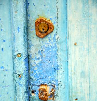 metal nail dirty     stripped paint in the brown   red wood door and rusty  knocker