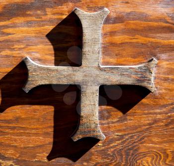 abstract cross   brass brown knocker in a   closed wood door  castiglione olona varese italy