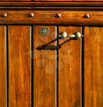 abstract  rusty brass brown knocker in a   closed wood door olgiate olona varese italy