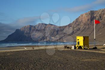 lifeguard chair red flag in spain  lanzarote  rock stone sky cloud beach  water  musk pond  coastline and summer 
