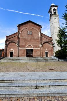 in  the cardano al campo old   church  closed brick tower sidewalk italy  lombardy  